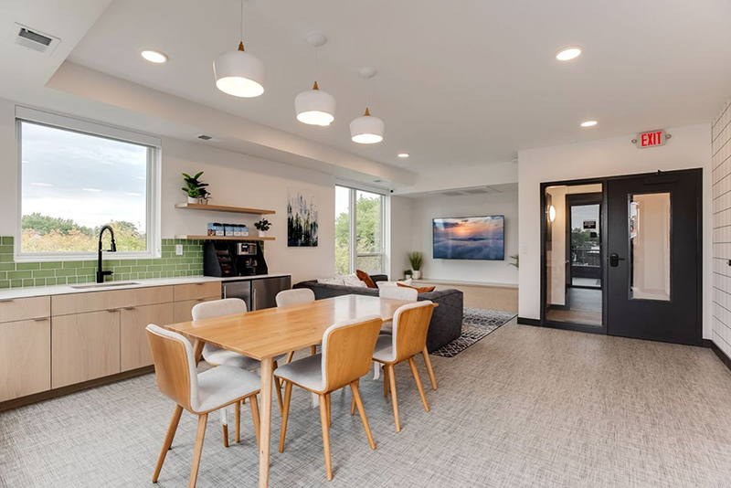 the community area with a kitchen, tv and seating
