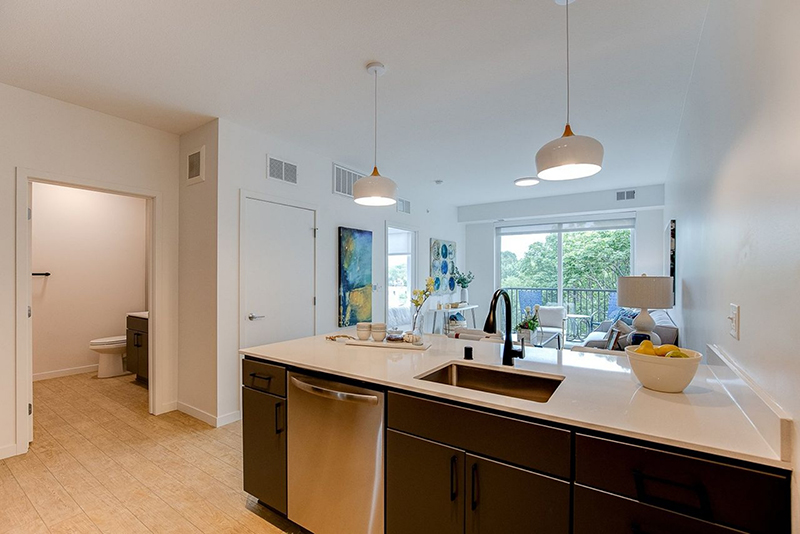 the kitchen and living room with a view of the bathroom