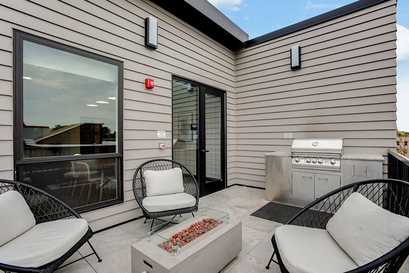 the community balcony with seating, a fire pit and a grill